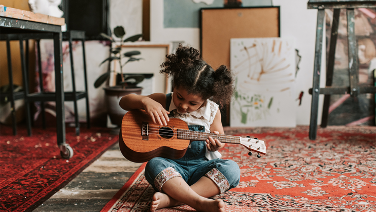 Bild på flicka som spelar gitarr 